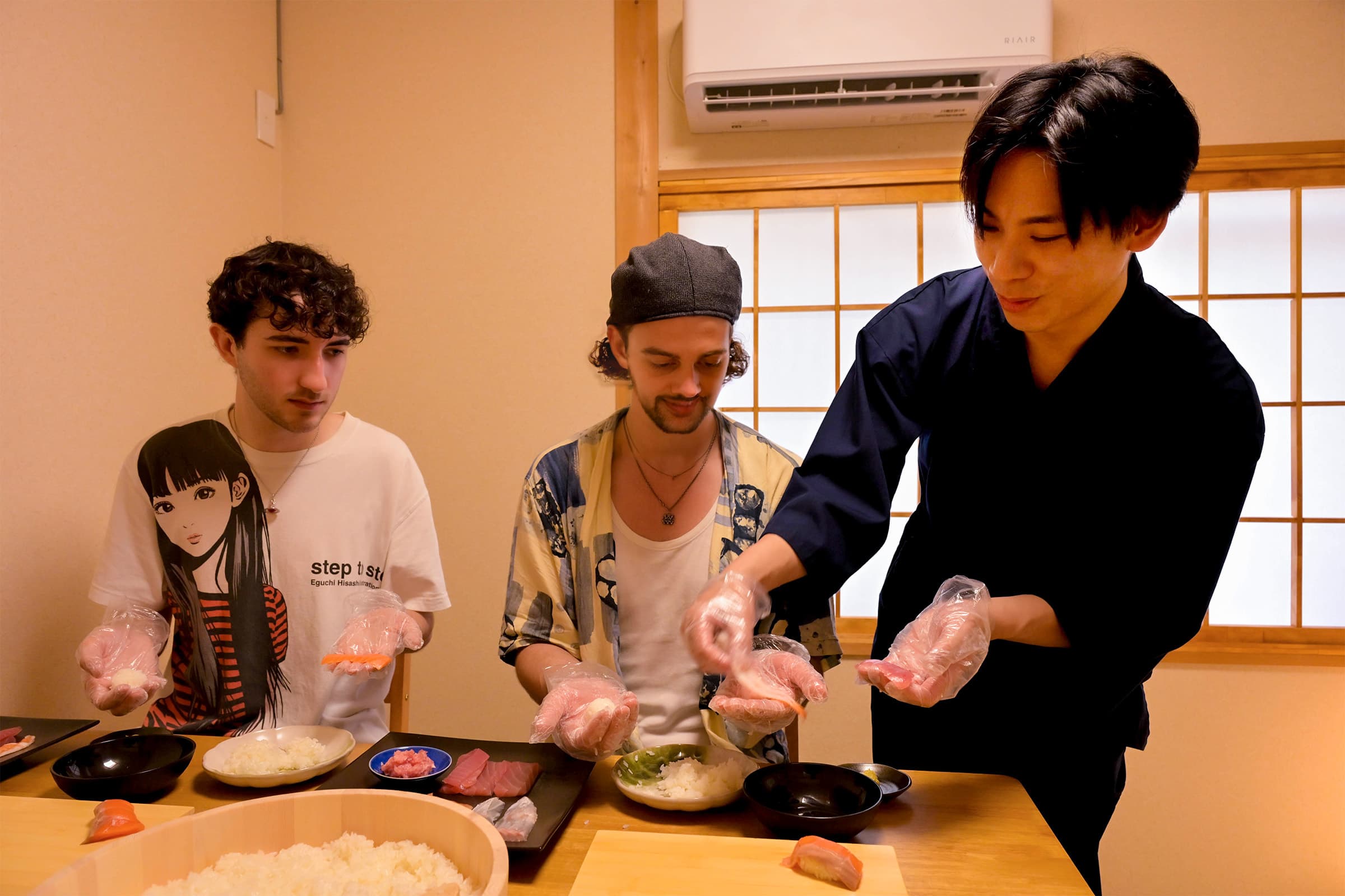 Host and guests gathered around the table, making sushi together